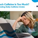 Person holding a cup of coffee while working at a desk